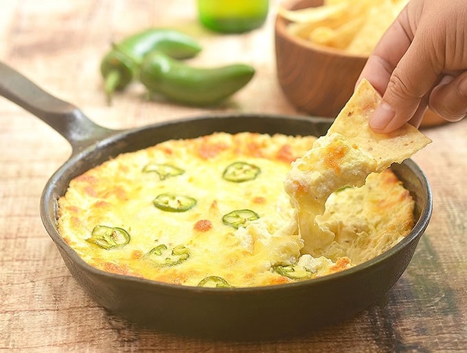 dipping corn chips in Cheesy Jalapeno Popper Dip