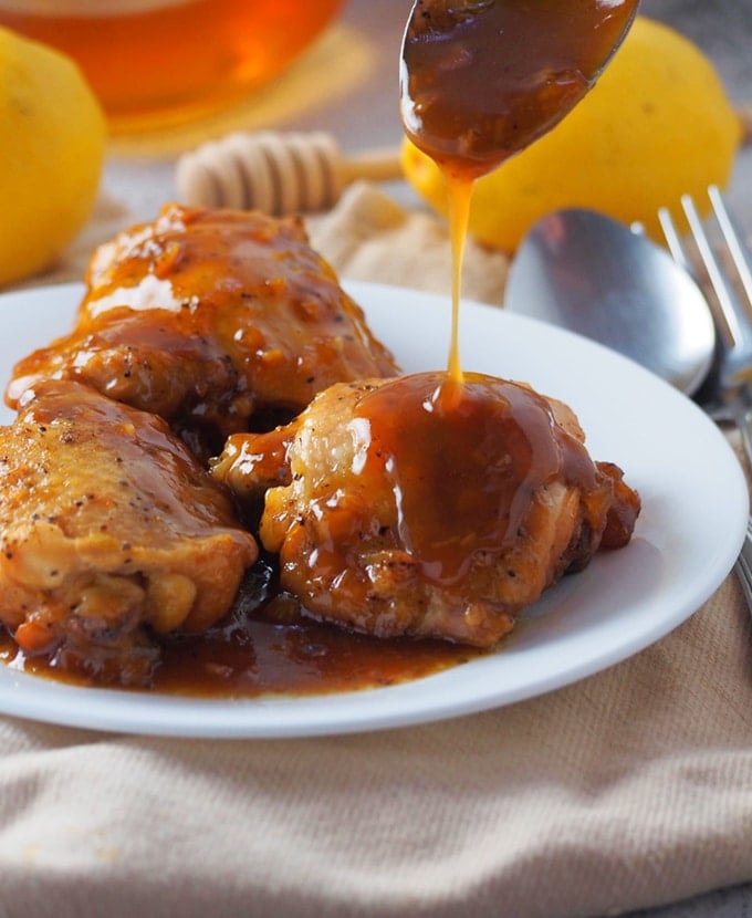 pouring honey lemon sauce on pressure cooker chicken thighs