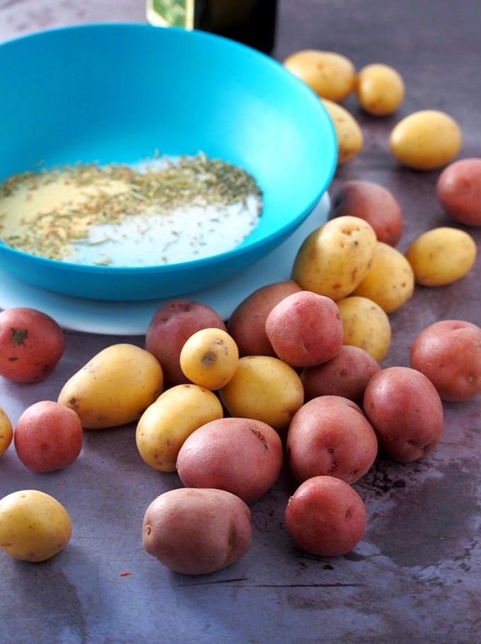 mini potatoes and seasonings in a blue bowl