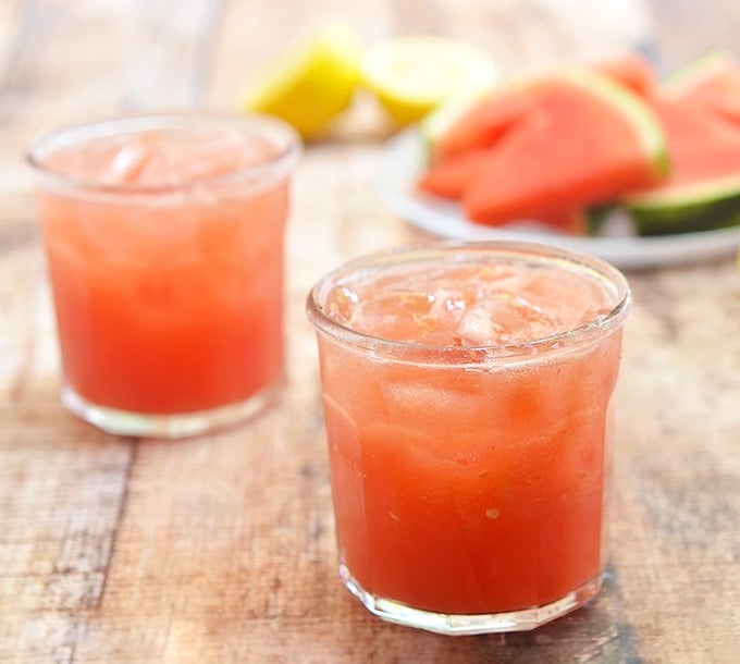 watermelon lemonade in clear glasses with watermelon and lemon slices on the side