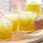holding a glass of mango lemonade