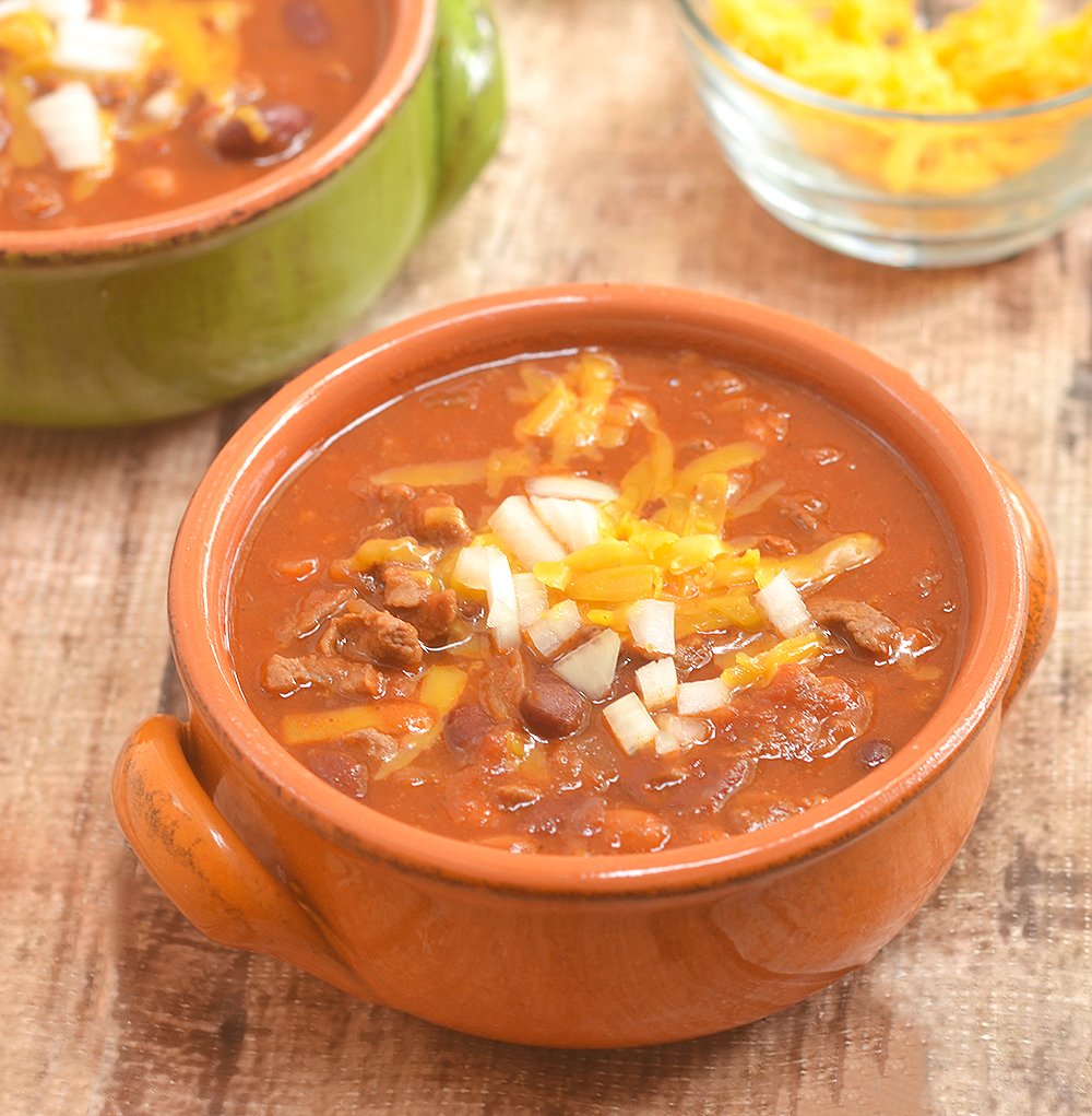 Cowboy Steak Chili with diced beef and tender beans in a smoky, chili-spiced tomato gravy is the ultimate chilly day food. Serve with various fixings and toppings!