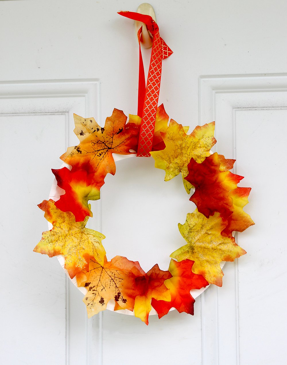 A simple Fall ribbon is the final touch to make this Fall wreath door decor ready