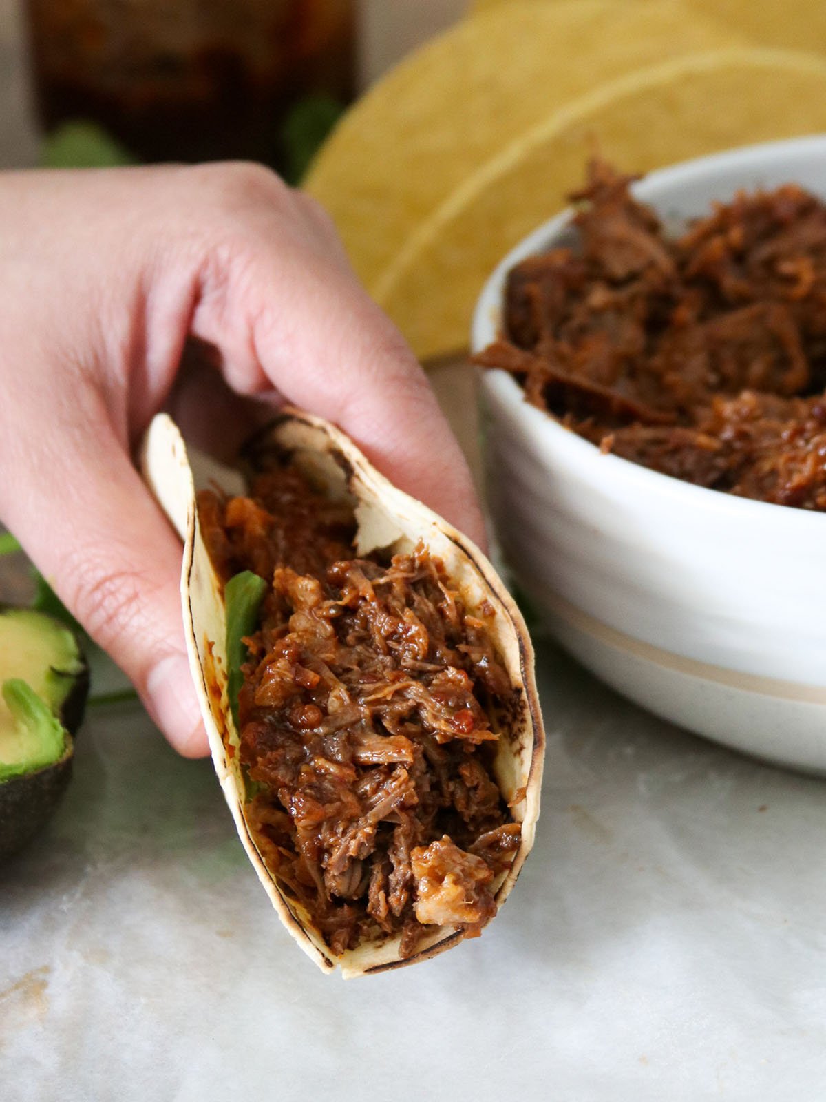 holding beef barbacoa taco with hand