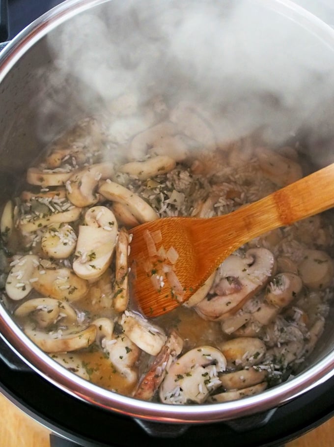 sauteing mushrooms in the Instant Pot with a wooden spoon
