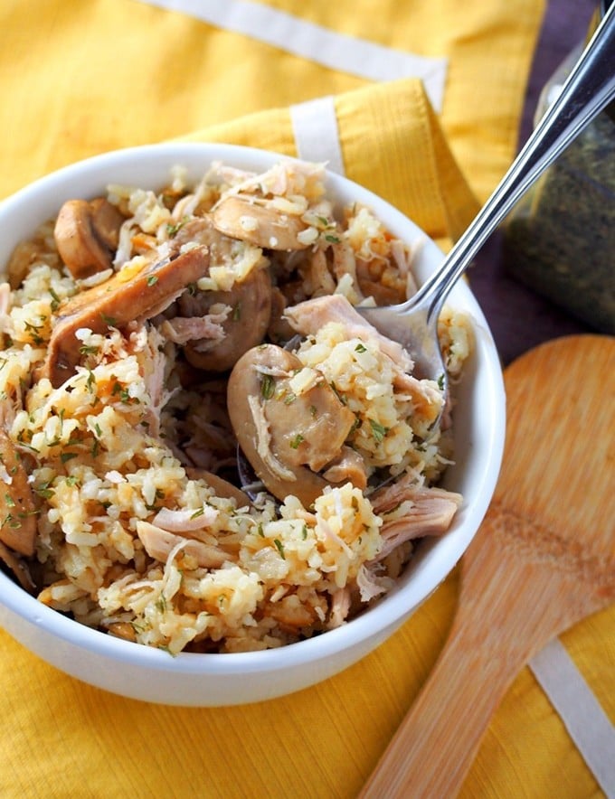 serving Instant pot rice casserole with chicken and mushrooms from a white bowl