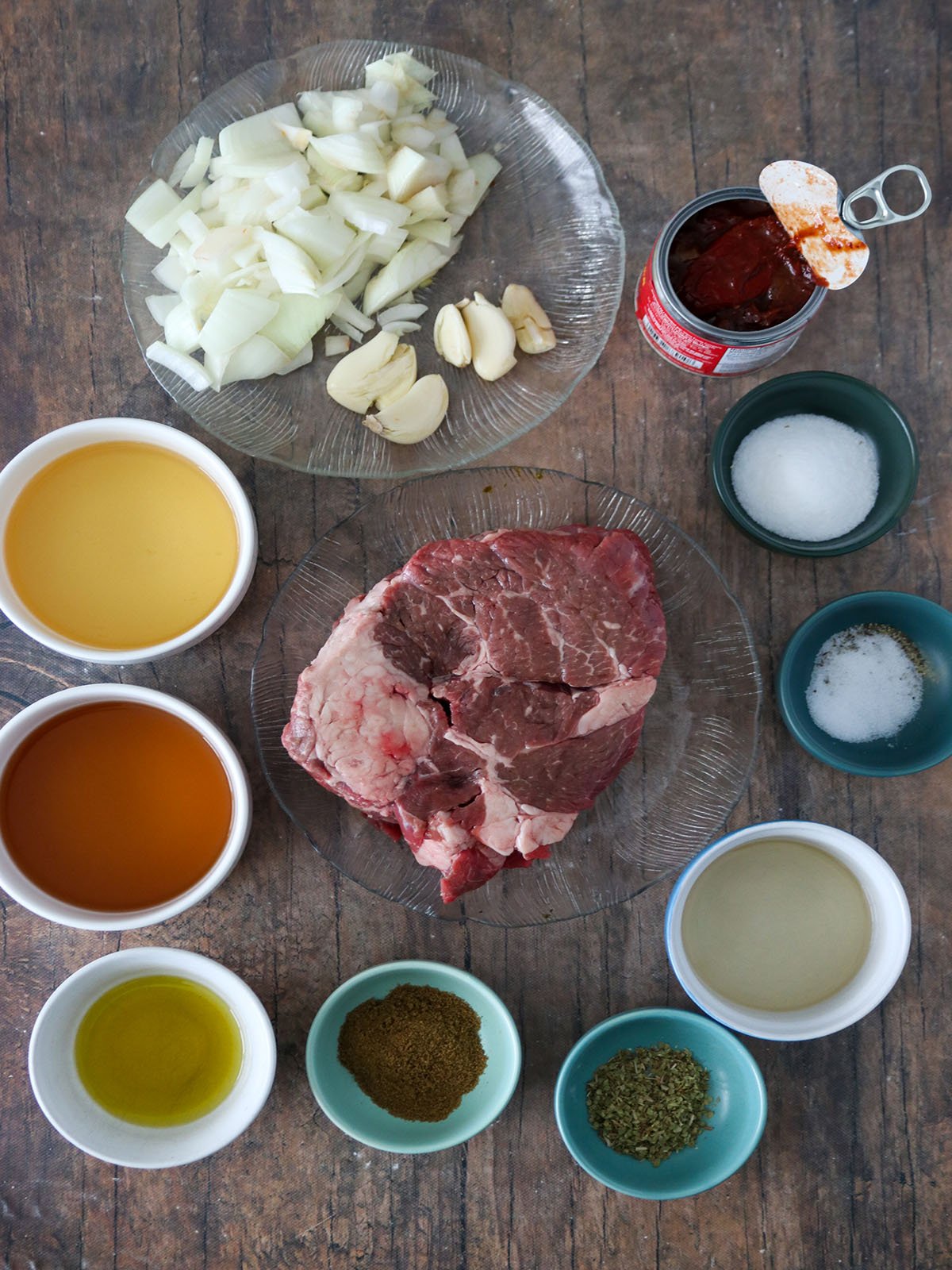 chuck roast, onions, garlic, oil, salt, cumin, vinegar, beer, sugar, dried oregano, beef broth, chipotle peppers in bowls