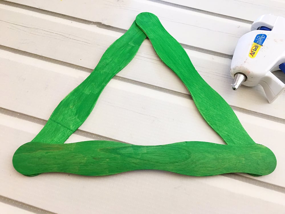 Hot glue the green sticks into a triangle shape to form your tree. 