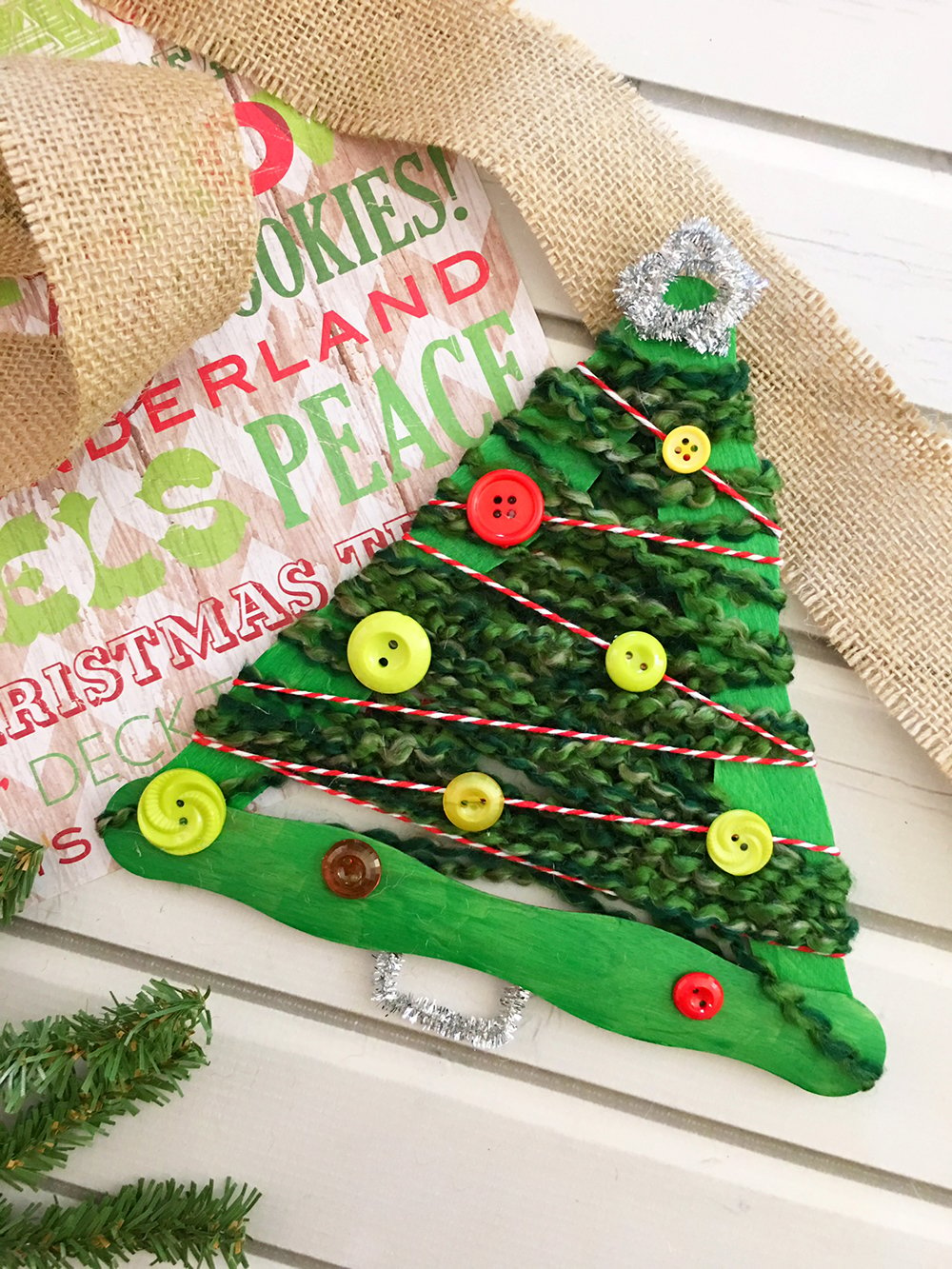 Yarn-wrapped Christmas tree craft stick ornaments are a great holiday project for the whole family. They're so easy to make and a festive addition to your Christmas decor-glue silver pipe cleaner on bottom of craft stick tree to resemble a tree trunk.