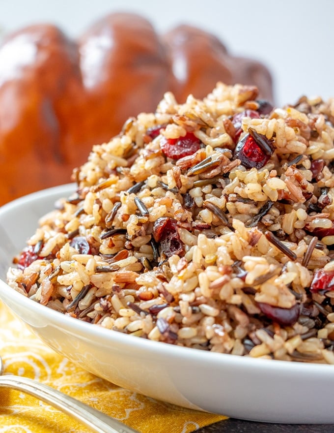 wild rice stuffing with cranberries and pecans in a white serving bowl