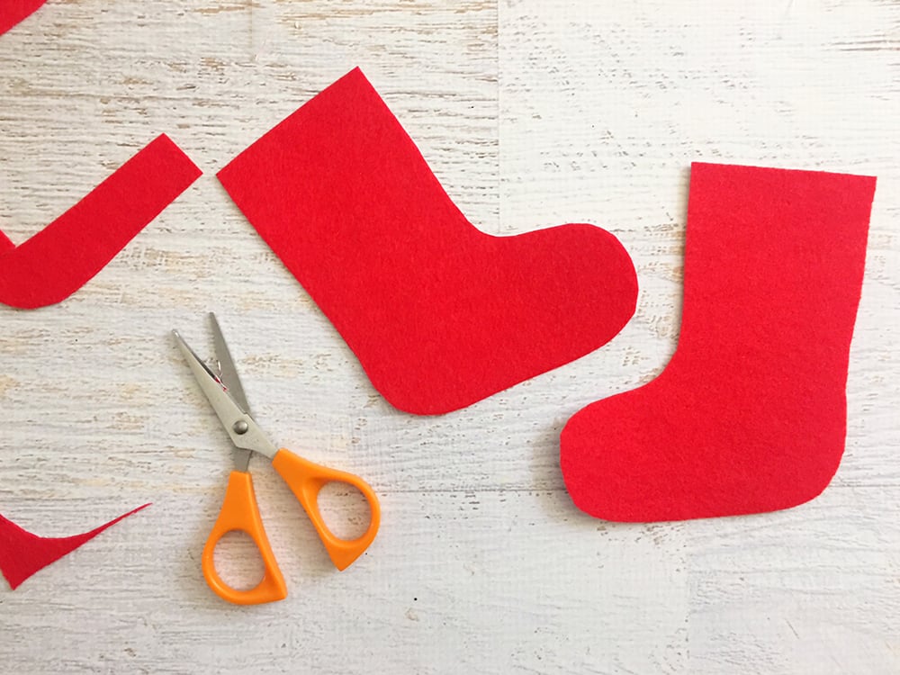 Felt Stocking Christmas Ornaments are an adorable addition to any holiday decor. So easy and fun to make with simple crafts supplies-draw and cut out sock shapes on red felt