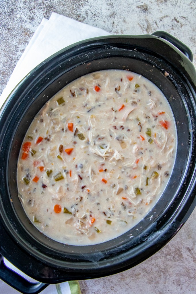 Slow Cooker Creamy Chicken Wild Rice Soup in a black crockpot