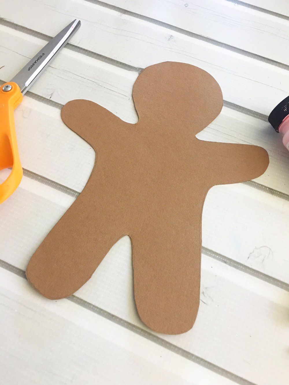 draw gingerbread man on brown card stock paper and cut with scissors.