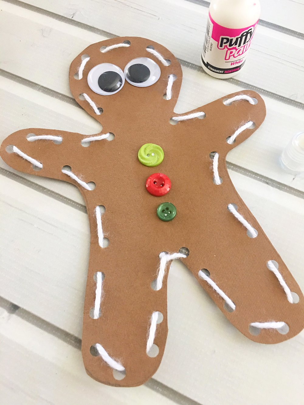 DIY Gingerbread Man Ornaments - Glue two googly eyes onto the face of the gingerbread man and three buttons onto the chest.