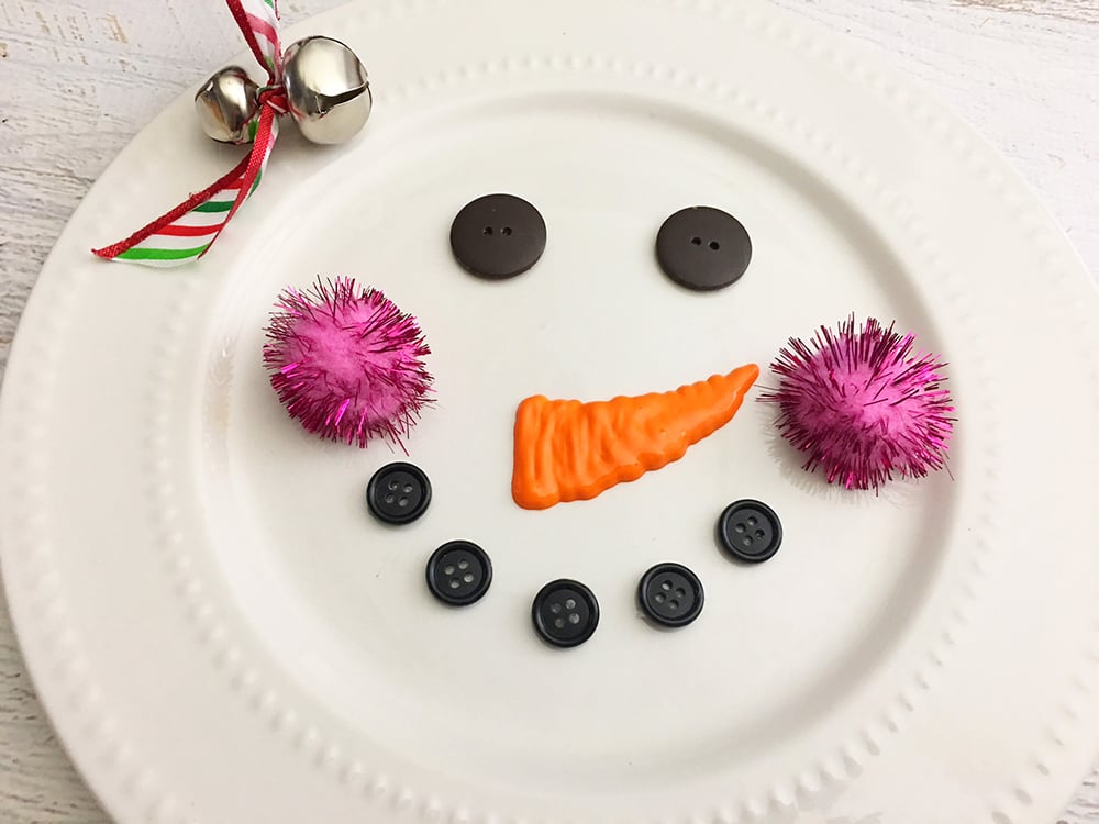 DIY Snowman Decorative Plate - glue jingle bells and pom poms onto the snowman plate