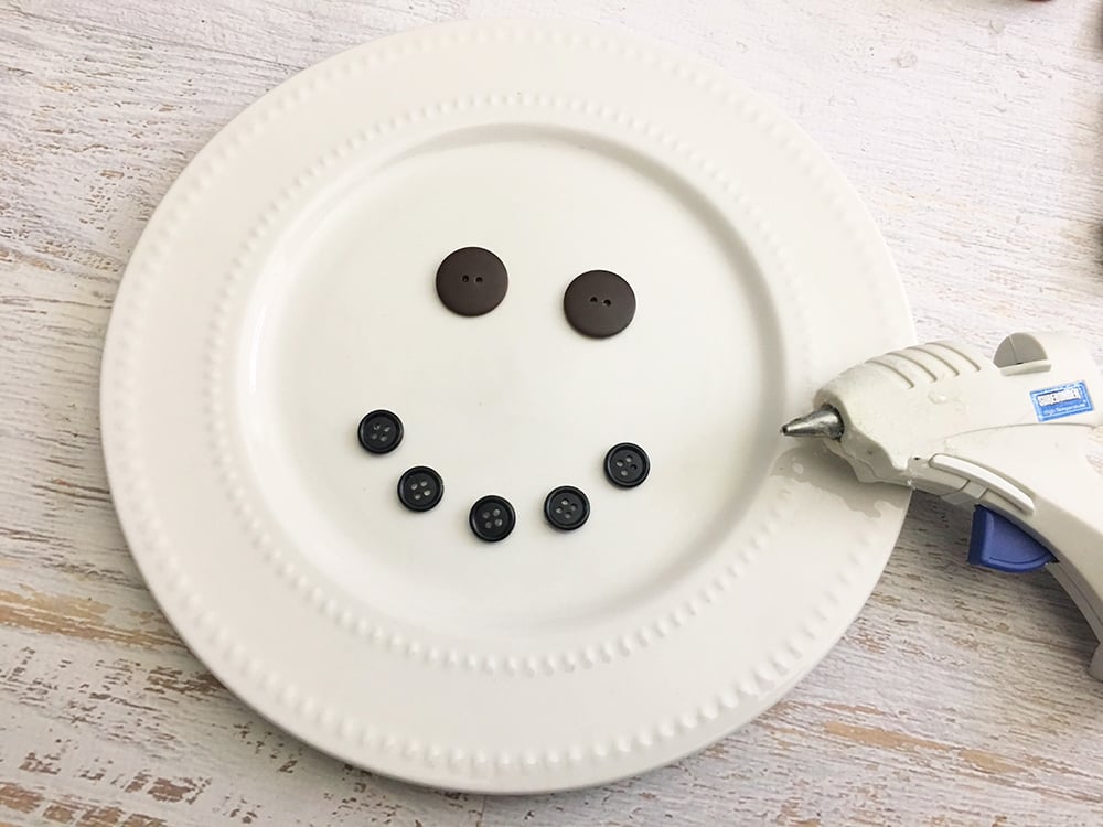 DIY Snowman Decorative Plate - glue two large buttons on plate for the eyes and five small buttons in the shape of a smile