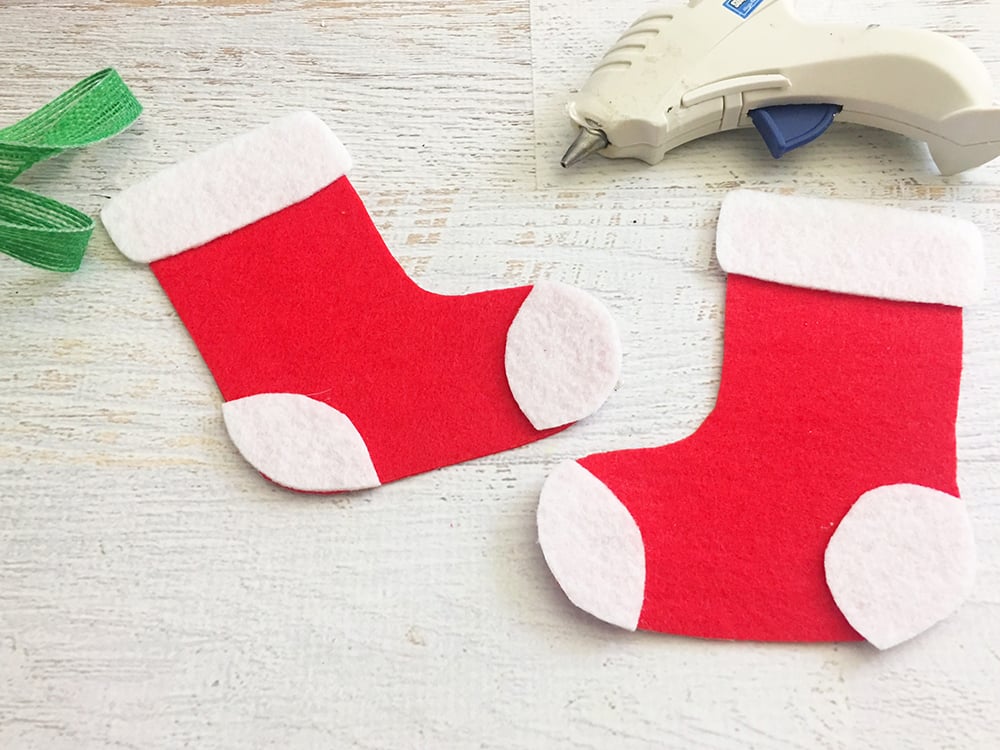 Felt Stocking Christmas Ornaments are an adorable addition to any holiday decor. So easy and fun to make with simple crafts supplies-cut out shapes of heel and toe part of stocking on white felt and glue on red felt stocking