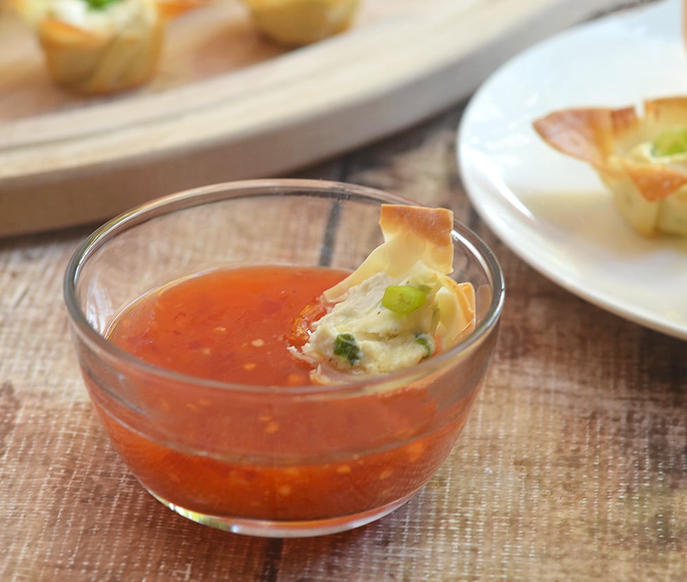 Crab rangoon wonton cups with sweet chili sauce for dipping.