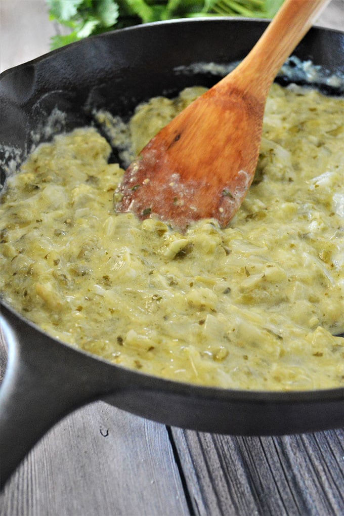 tomatillo sauce with beaten eggs in cast-iron skillet