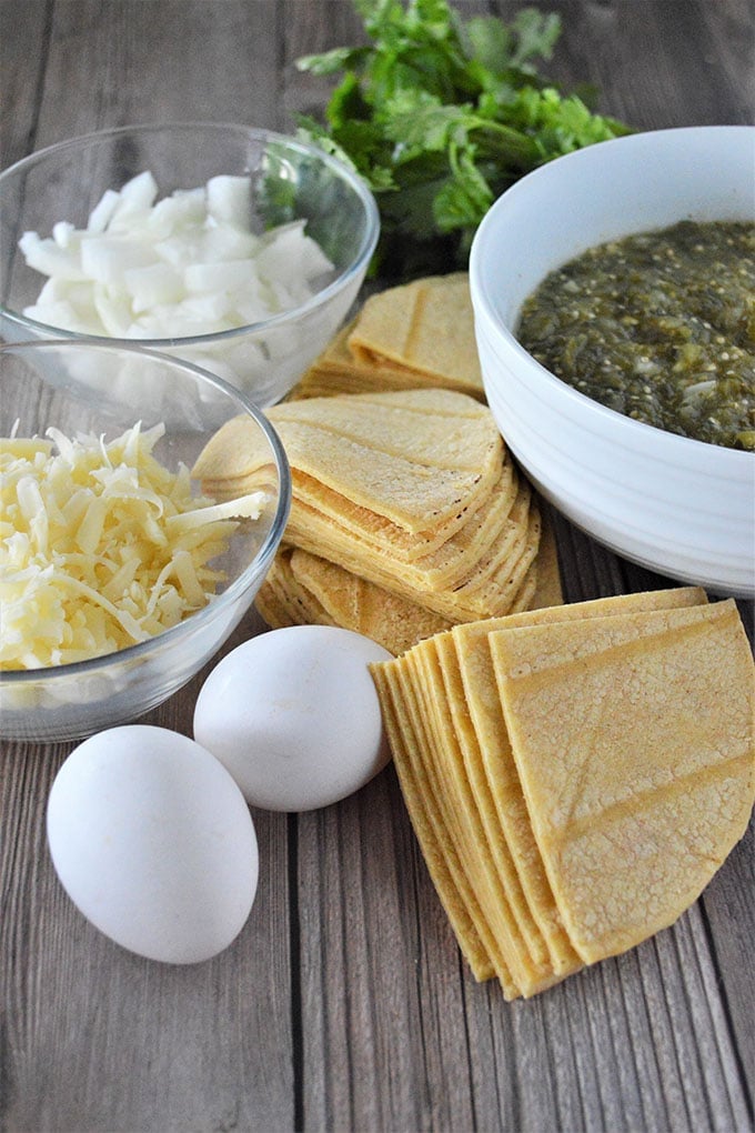 cut corn tortillas, eggs, shredded cheese, tomatillo sauce, chopped onions, cilantro