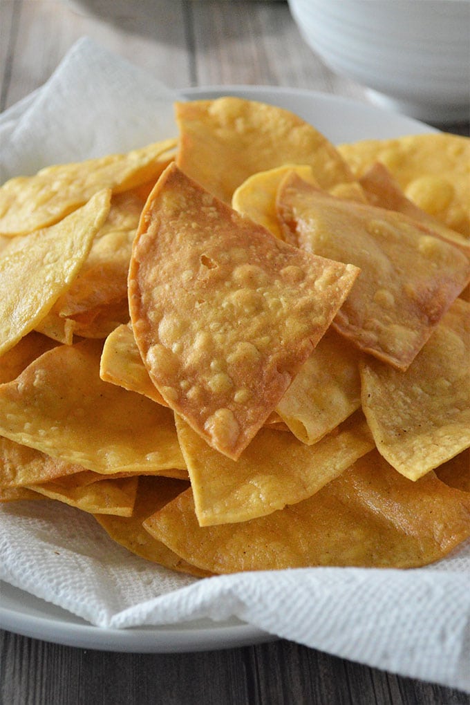 crispy fried tortilla chips on a paper-lined plate