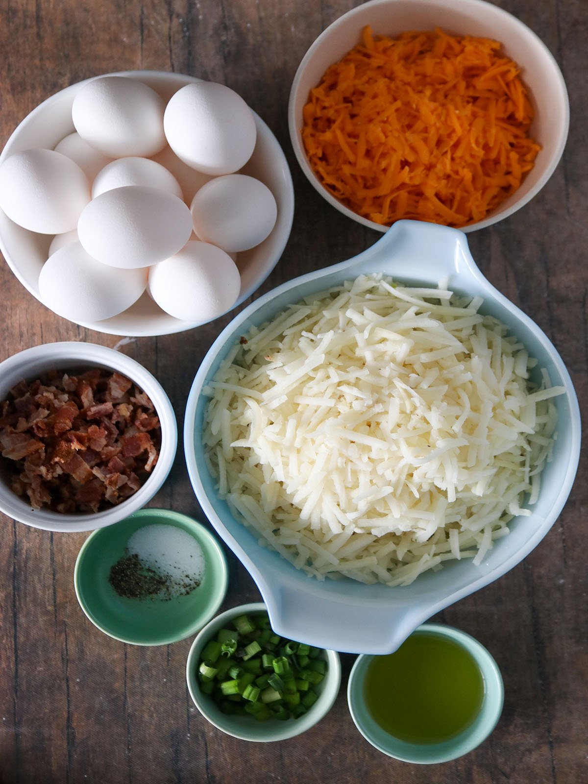 eggs, shredded hashbrown, bacon, green onions, cheese, salt, pepper, olive oil in bowls