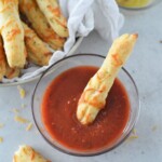 dipping Two-Ingredient Breadsticks in a bowl of marinara sauce.