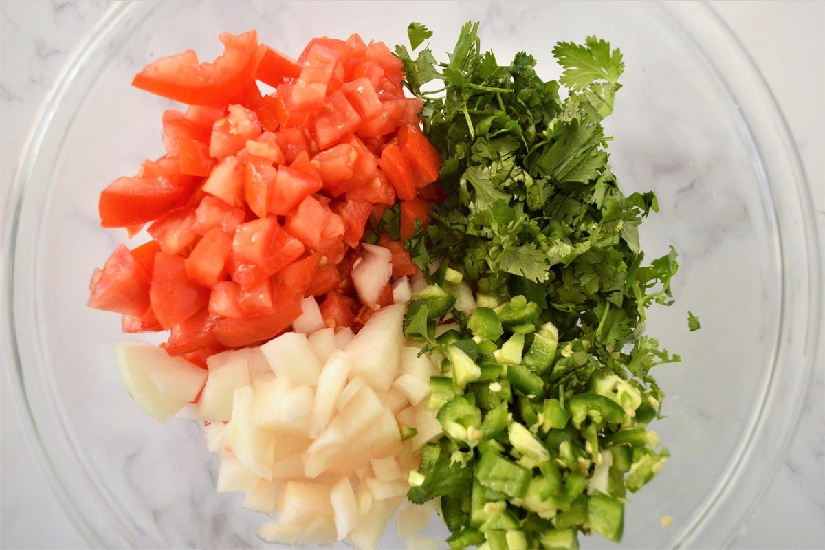 chopped tomatoes, cilantro, onions in a bowl