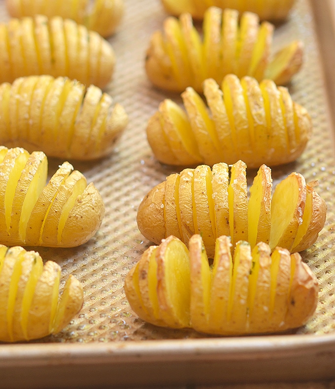 Baby Yukon Potatoes cut hasselback-style and on a sheet ready to bake