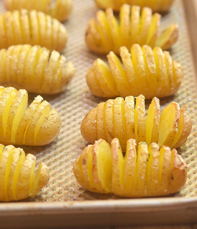 Baby Yukon Potatoes cut hasselback-style and on a sheet ready to bake