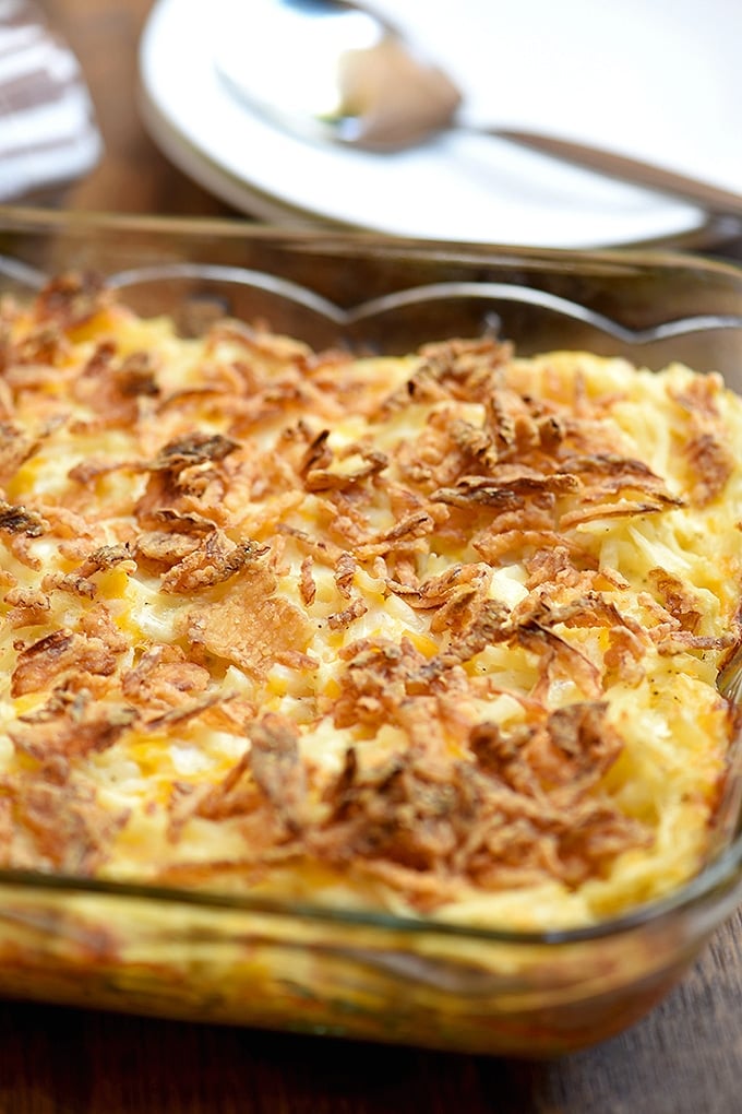 funeral potatoes baked in a clear casserole dish with french fried onion topping