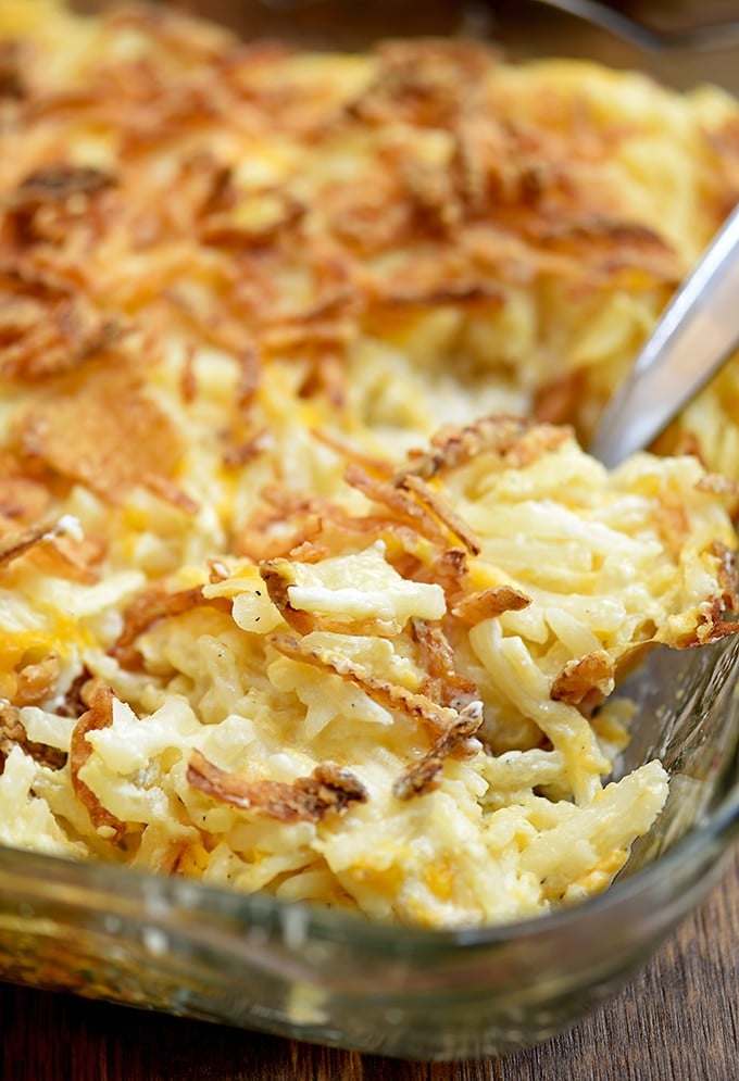 hashbrown potato casserole with french-fried onions in a clear baking dish