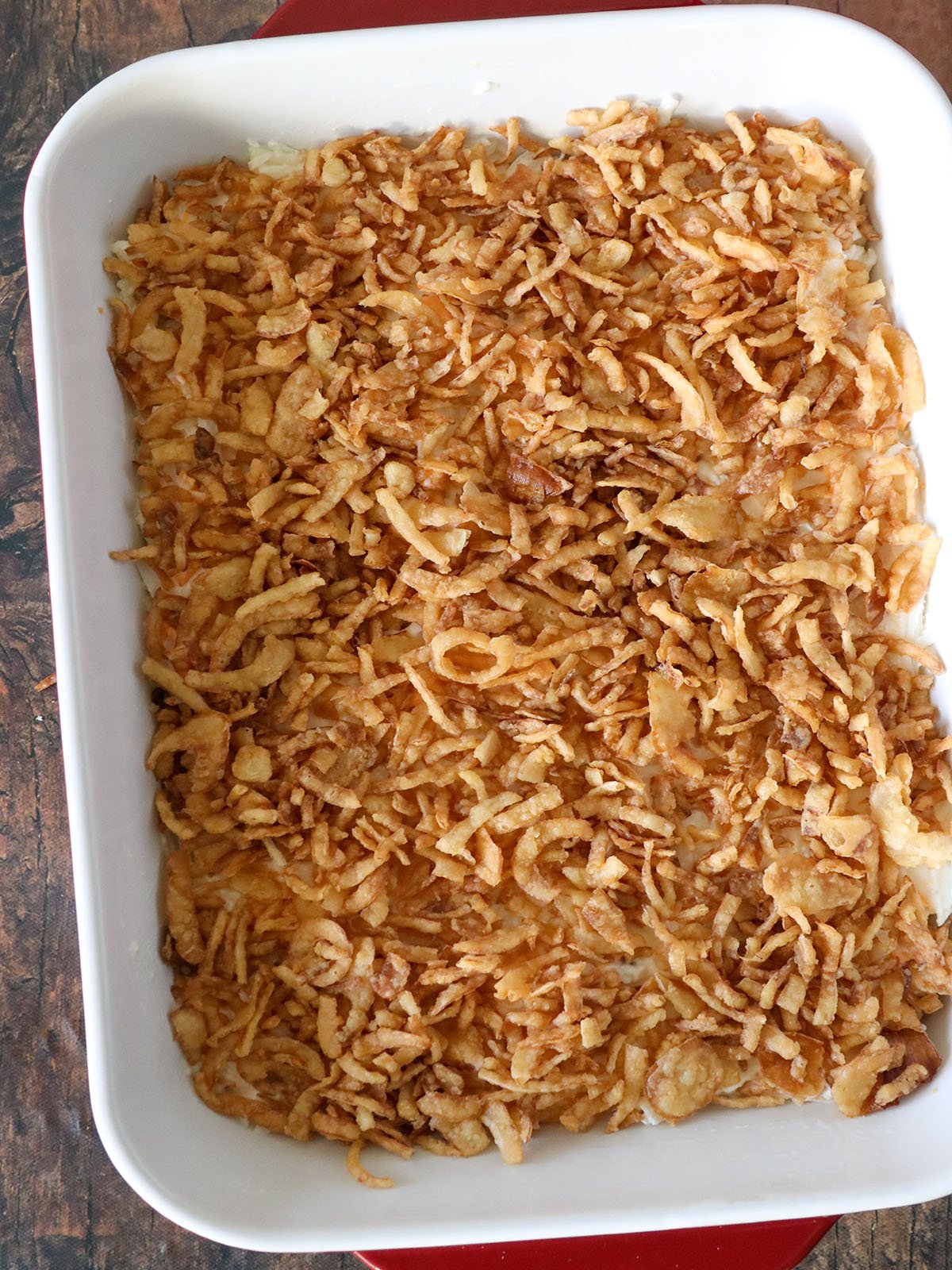 baked funeral potatoes with crispy french-fried onions in a casserole