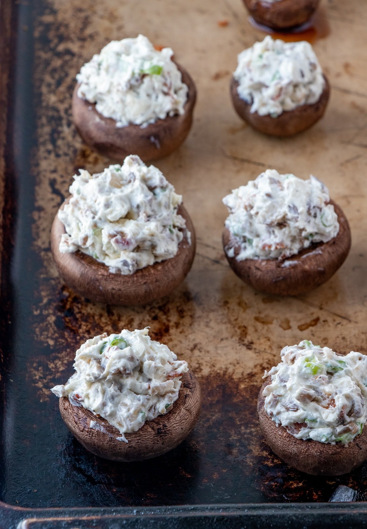 stuffed mushrooms ready to bake on a baking sheet