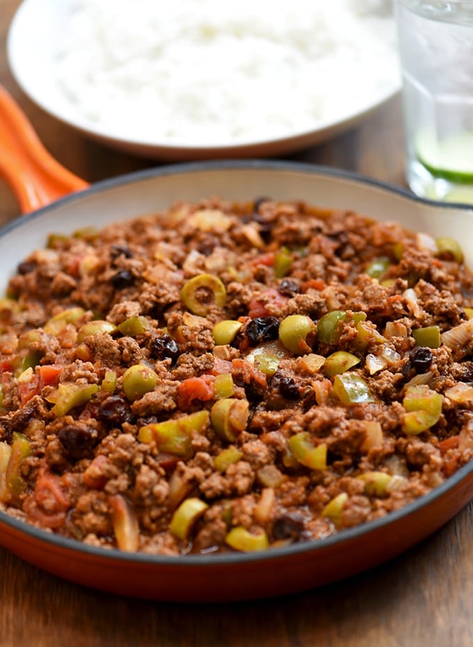 Cuban picadillo served in a orange skillet with a side of rice