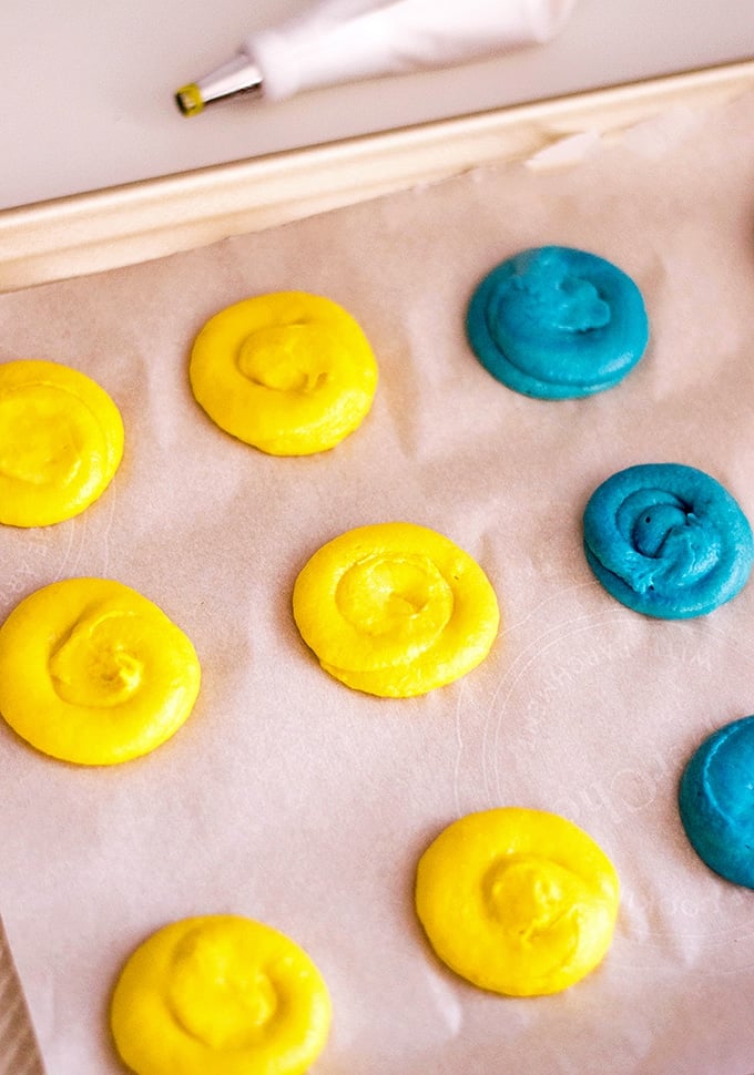 Piping the colored Minion whoopie batter on a baking sheet