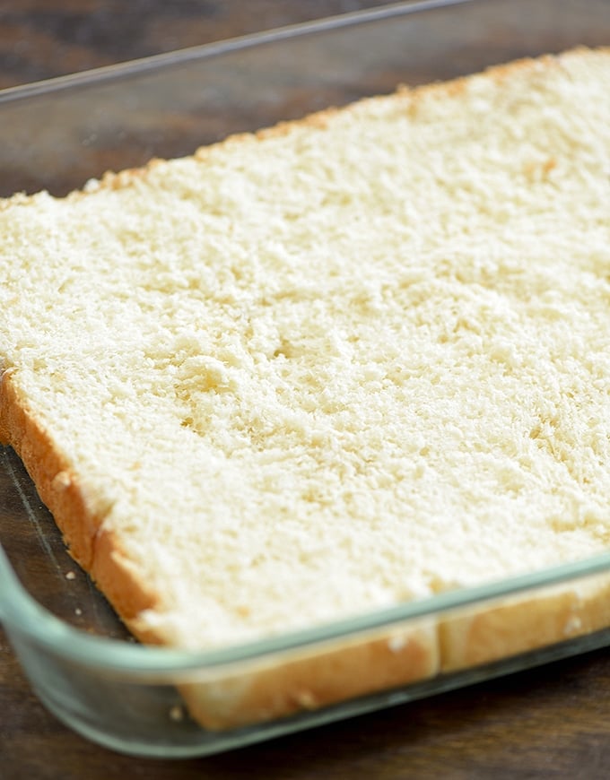 bakery rolls cut horizontally in half and placed in a casserole dish for Philly cheesesteak sliders