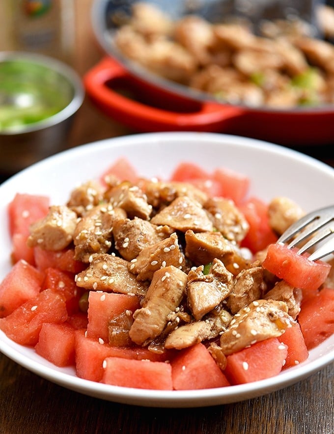 sesame chicken and watermelon served on a plate