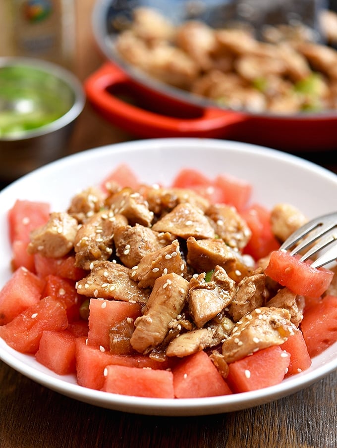 sesame chicken and watermelon served on a plate