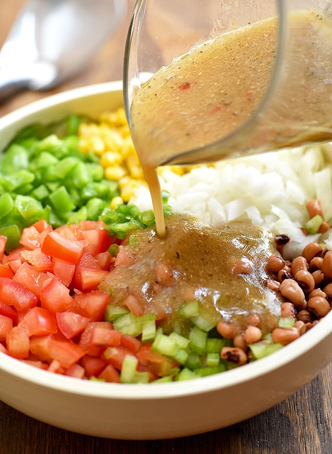 adding Italian dressing to a bowl of Texas caviar