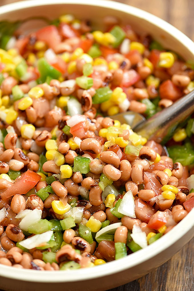 Texas Caviar dip with black-eyed peas, grilled corn, tomatoes, bell peppers, onions, jalapeno, and Italian dressing in a serving bowl