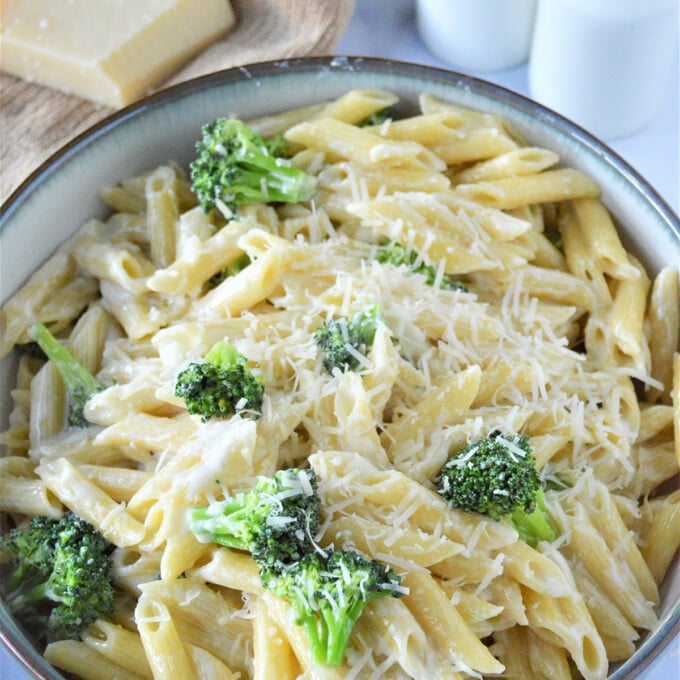 pasta alfredo with broccoli and parmesan cheese in a skillet