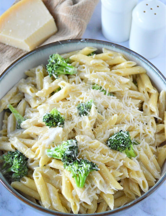 pasta alfredo with broccoli and parmesan cheese in a skillet