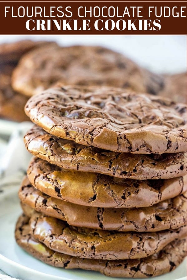 Flourless chocolate fudge cookies on a plate with a glass of milk on the side