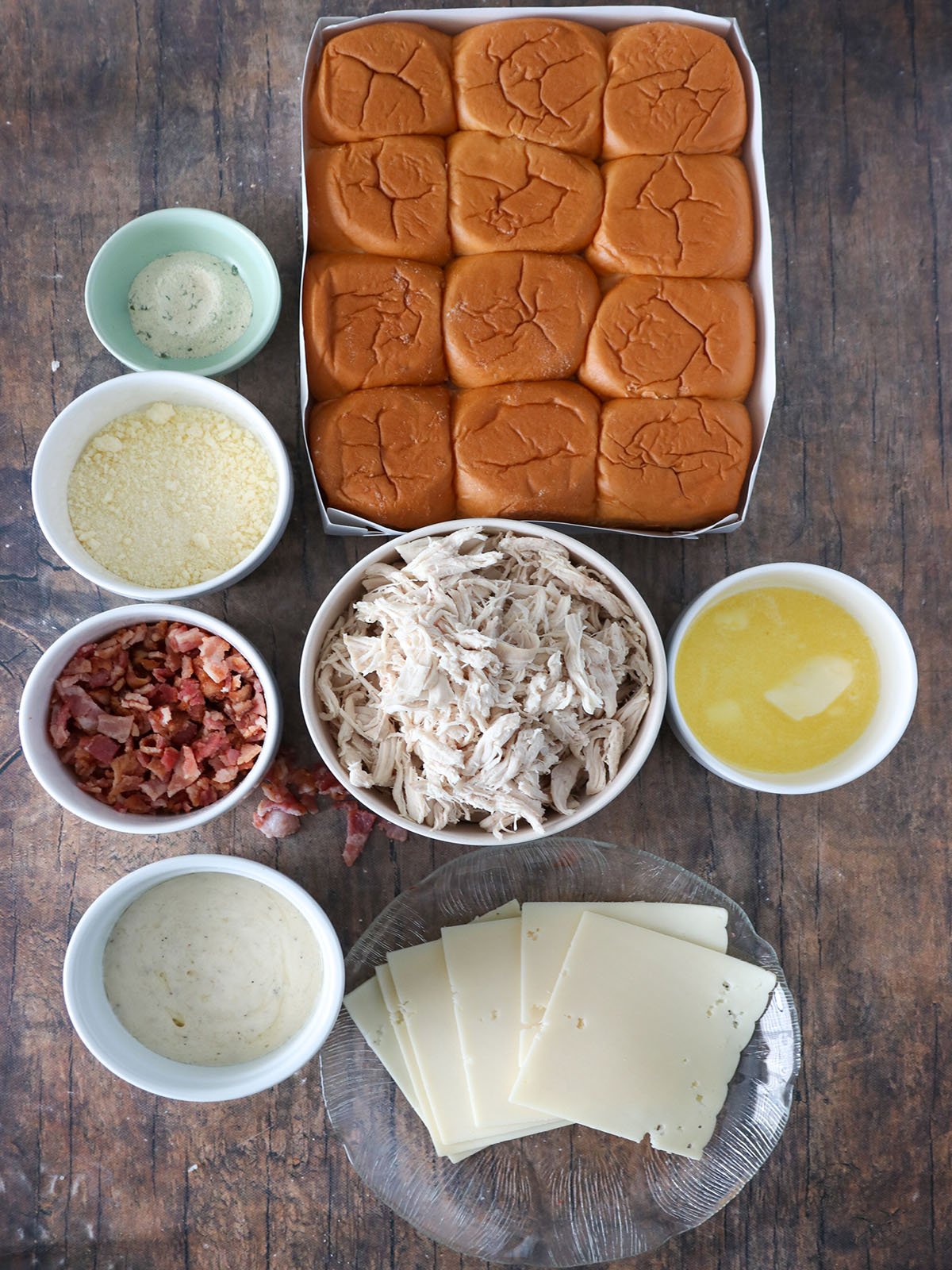 bread rolls, parmesan cheese, bacon, cheese, butter, chicken, ranch dressing in bowls