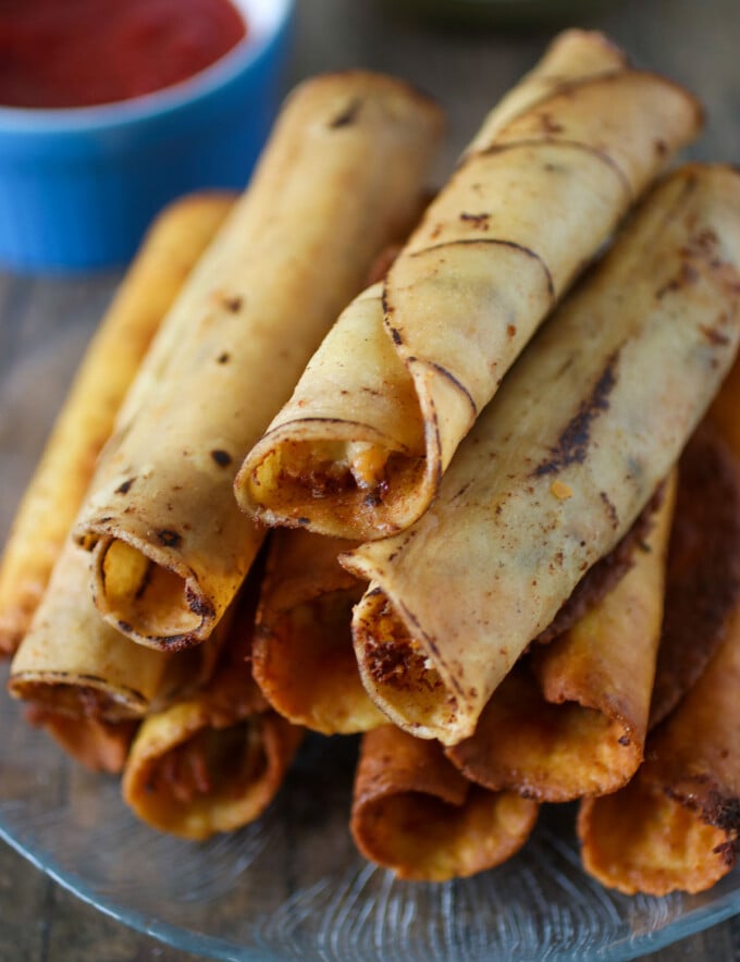 cream cheese chicken taquitos with sides of sour cream and salsa for dipping