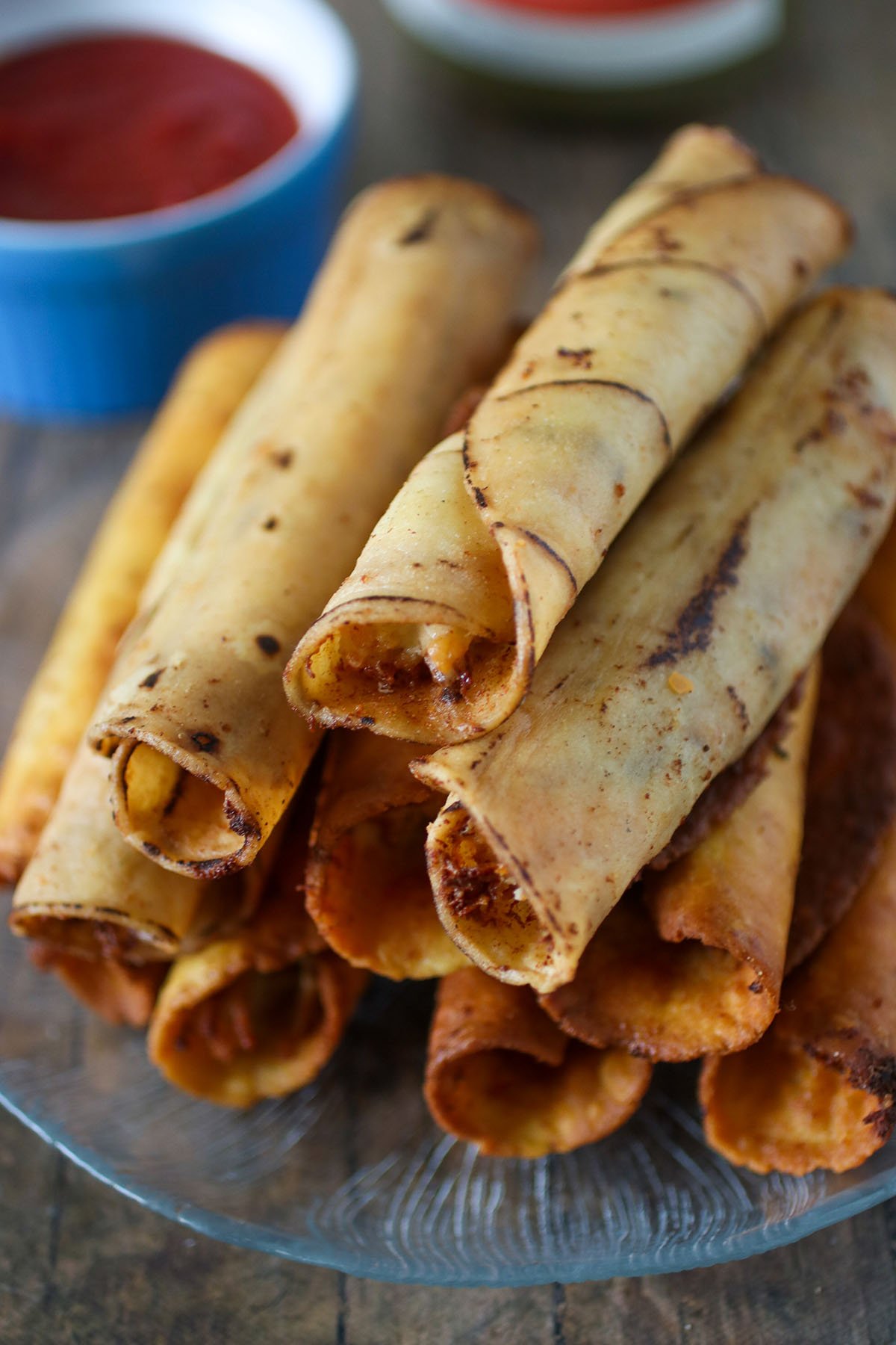 cream cheese chicken taquitos with sides of sour cream and salsa for dipping