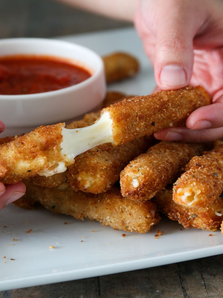 stretching mozzarella cheese with fingers.