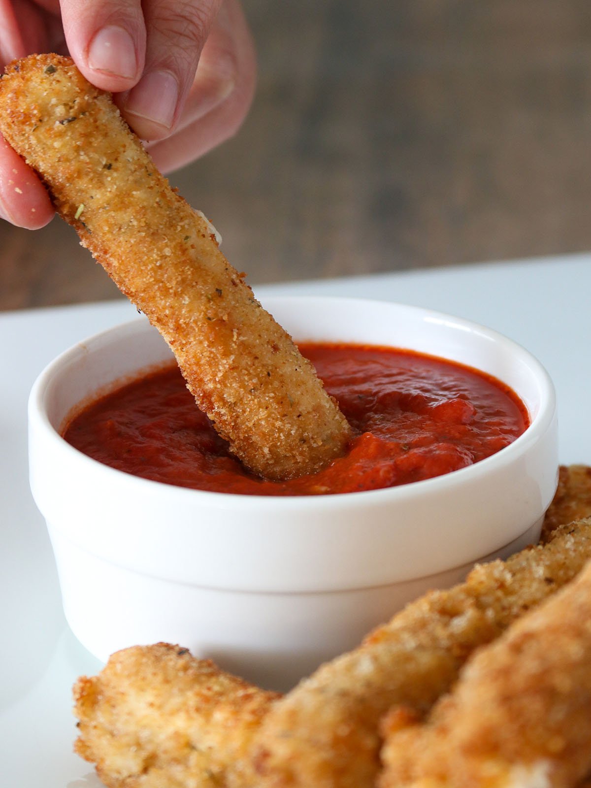 dipping mozzarella cheese sticks in marinara sauce