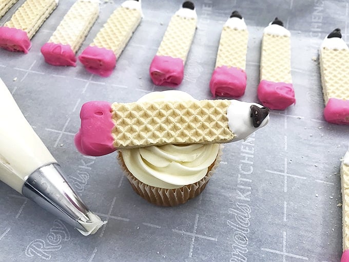 making pencil back-to-school cupcakes with frosted vanilla cupcakes and candy-coated sugar wafers